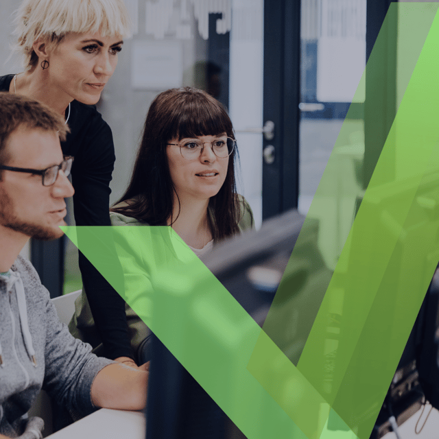 Team collaborating at computers with a green checkmark overlay.